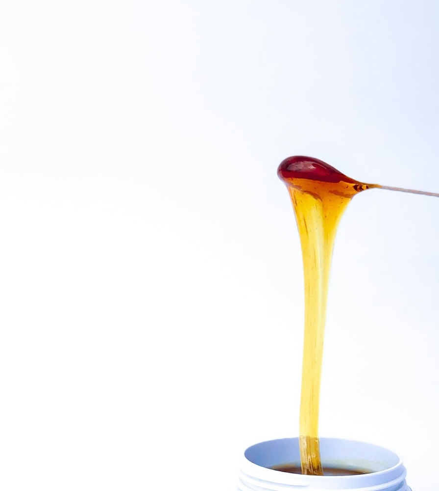 Golden wax dripping from a spatula
